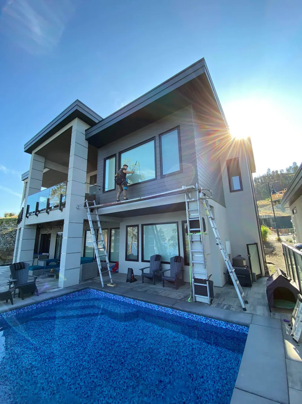 AndPro completing exterior window cleaning on a modern Kelowna home